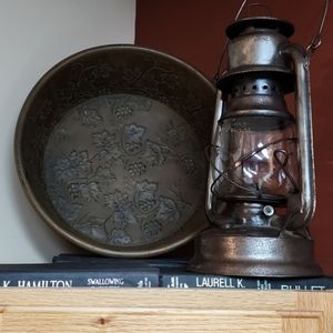 Ornate round metal table decoration with claw feet.